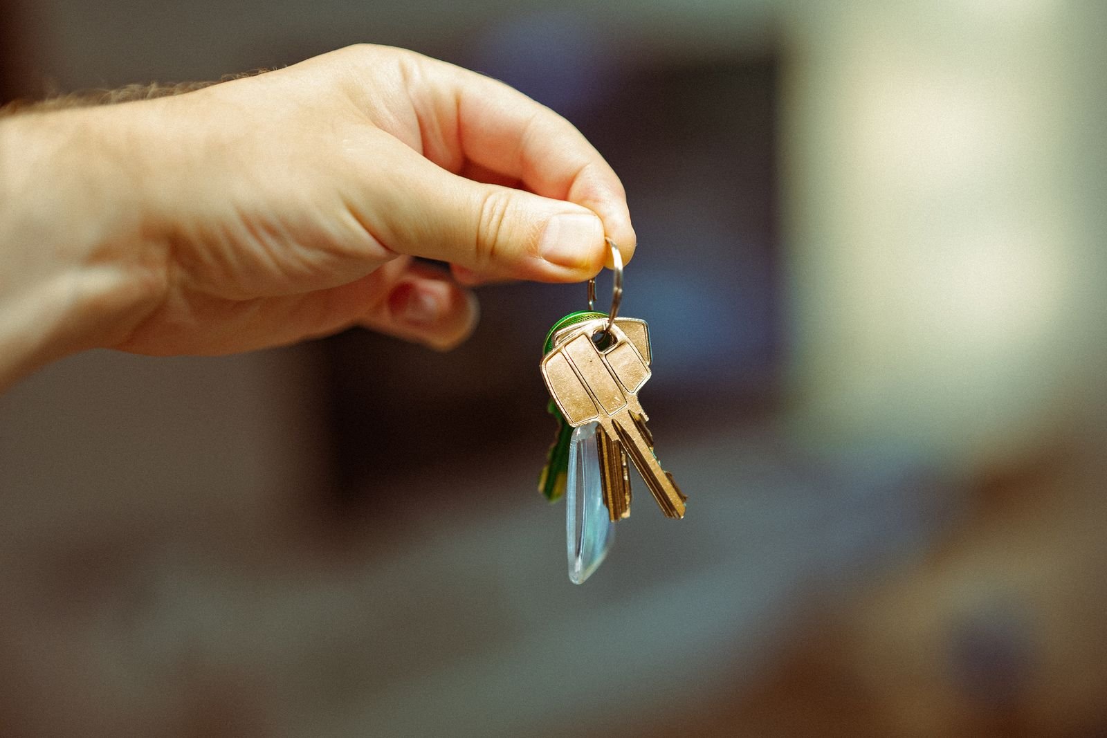 Main tenant un trousseau de clés de maison, symbole d'une clé perdue et de la nécessité de sécuriser rapidement son accès