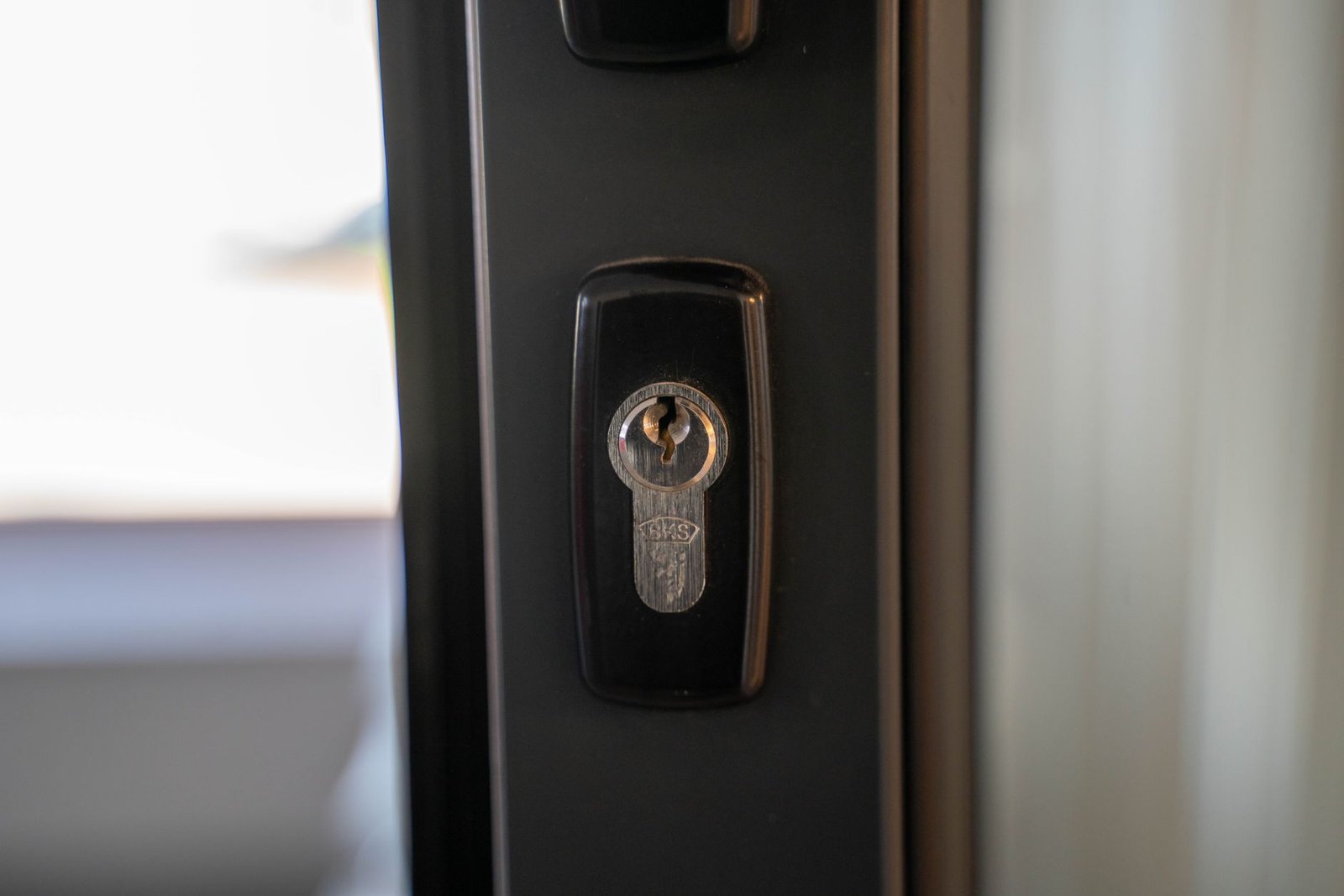 Clé engagée dans le cylindre européen d'une porte d'entrée sombre, entrée de serrure en gros plan