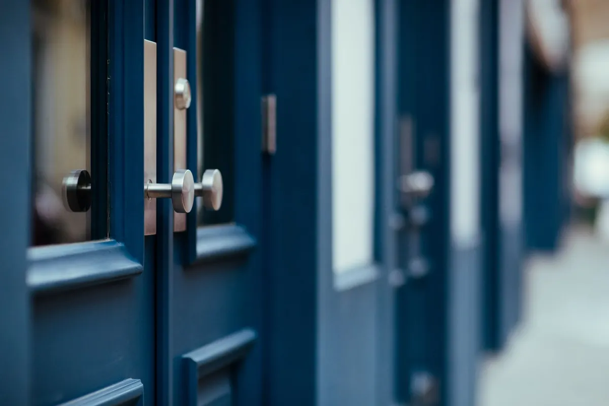 Portes d&rsquo;entrée en bois peint équipées de leurs serrures, dans une rue