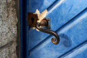 Entrée de serrure et poignée en fer forgé sur une porte en bois bleue ancienne