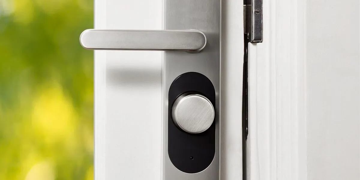 Serrure connectée à bouton motorisé installée sur une porte d&rsquo;entrée