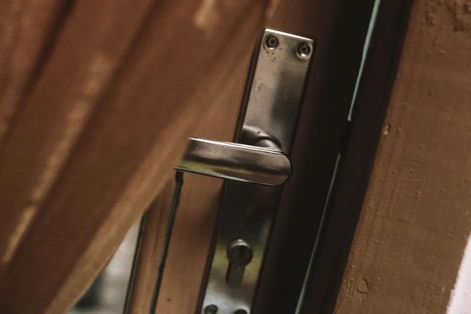 Poignée et cylindre européen d'une serrure à larder sur une porte en bois, la pièce que le serrurier remplace le plus souvent